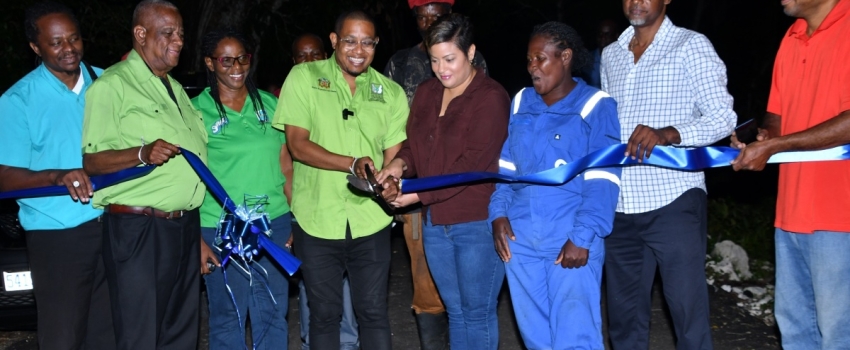 Minister of Agriculture, Fisheries and Mining Hon. Floyd Green (fourth left) cuts the ribbon to officially open a section of the rehabilitated Spring Garden roadway in St. Ann on Wednesday (November 22). He is joined by (from left) Director of Engineering at the Rural Agricultural Development Authority (RADA), Clayton Williams; State Minister in the Ministry of Agriculture, Fisheries and Mining, Hon. Franklyn Witter; Farmer Barbara West; Member of Parliament for North West St. Ann, Krystal Lee; Farmer Jahbl