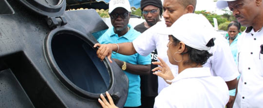 Business Development Manager at Rock Solid Plastics Limited, Ashley Neisbeth (centre), and Minister of Agriculture, Fisheries and Mining, Hon Floyd Green (third from left), look inside an empty water tank created by Rock Solid Plastics Limited at the St. Bess Agri-Fest held at the Santa Cruz Community Centre SDC Complex on Friday, June 9, 2023. Looking on are Acting Chief Executive Officer for the Rural Agricultural Development Authority (RADA), Winston Simpson (left), and Senior Director of Production, Mar