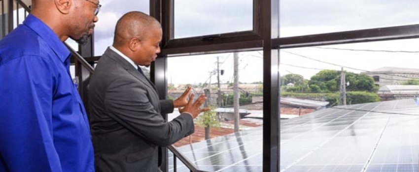 Minister of Agriculture, Fisheries and Mining, Hon. Floyd Green (right) and Chief Executive Officer, National Irrigation Commission (NIC), Joseph Gyles, examine the 30-kilowatt grid-type solar system installed at the NIC's expanded Operations Centre and Rio Cobre office in St. Catherine, during a commissioning ceremony at the facility on Wednesday (September 13).
