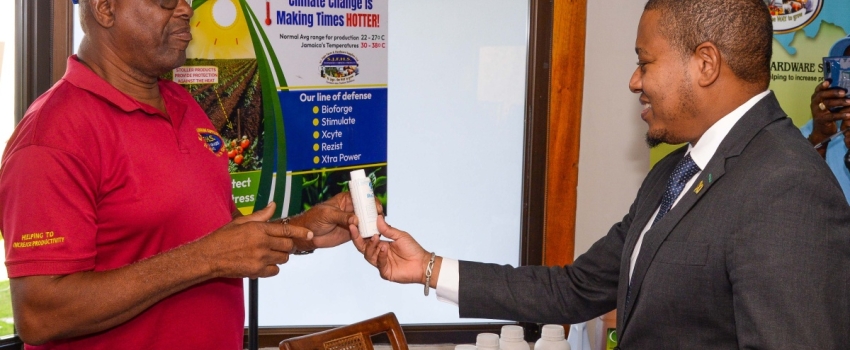 Minister of Agriculture, Fisheries and Mining, Hon. Floyd Green (right) looks at a product to promote plant health during a visit to the St. Jago Farm and Hardware Supplies booth at the World Soil Day Seminar on Tuesday (December 5) at the Jamaica Conference Centre, downtown Kingston. Highlighting the benefits of the solution is Product Development Officer at the St. Jago Farm and Hardware Supplies, Cassidy Beckford.